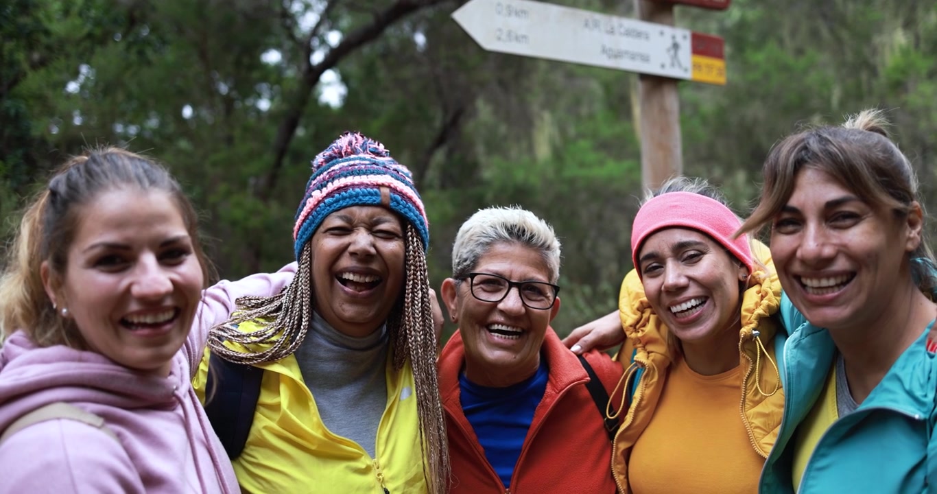 Gruppo di donne diverse che sorridono insieme durante un'escursione