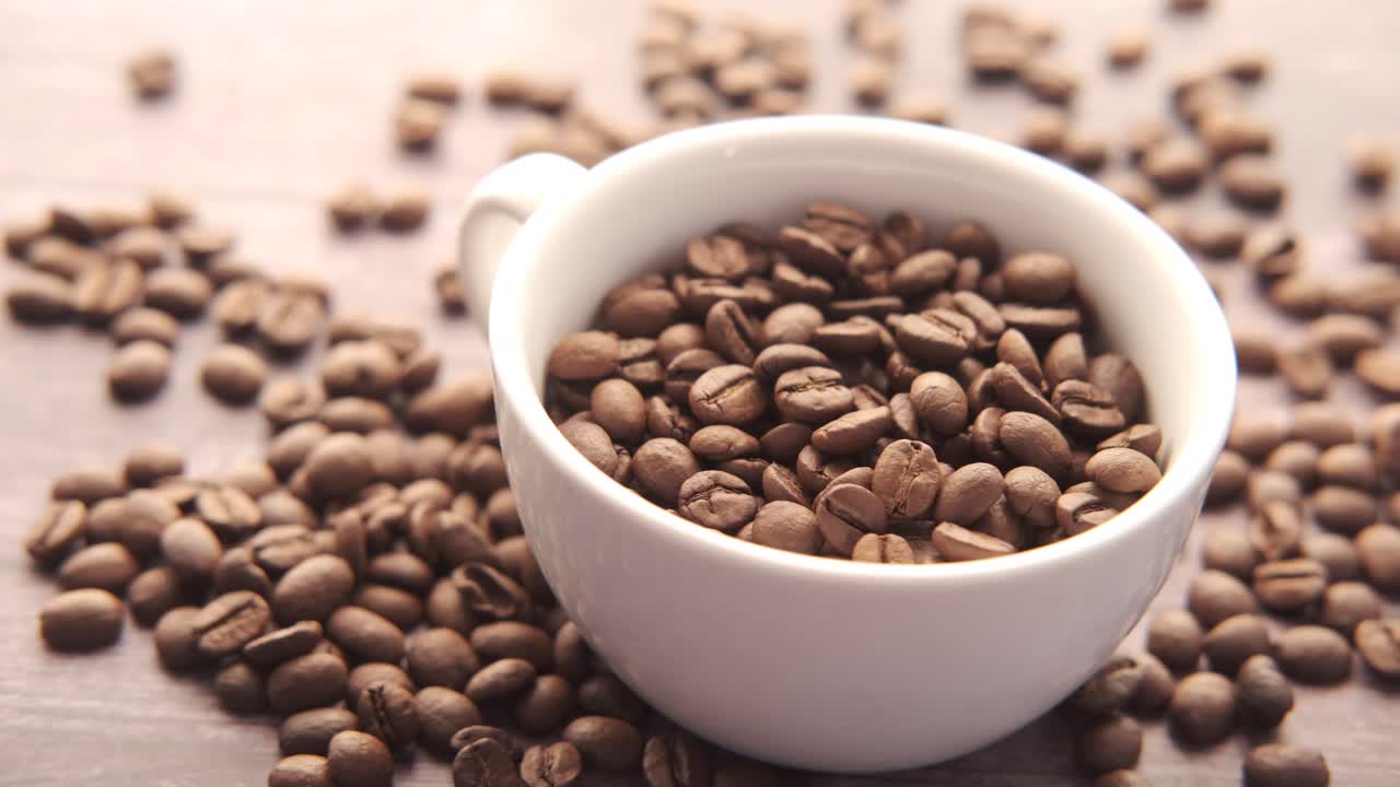 Fagioli di caffè in una tazza bianca