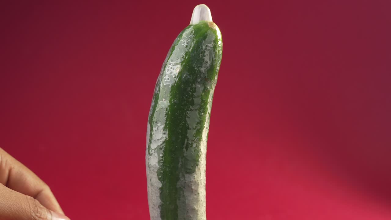 Dimostrazione di come si usa un preservativo, infilandolo su un cetriolo