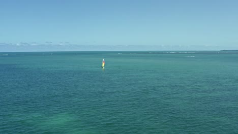 muñeca en toma aérea siguiendo un colorido velero desde la playa tropical de bessa en la capital costera de joao pessoa, paraiba, brasil en un cálido y soleado día de verano