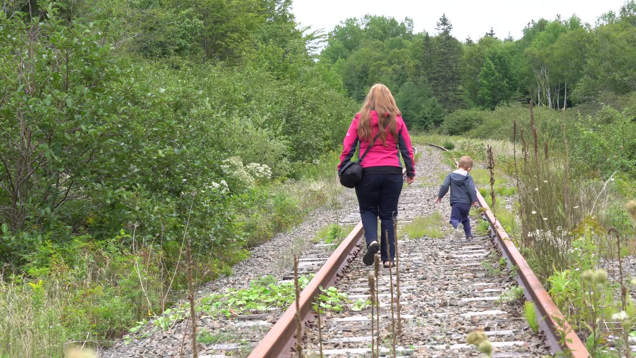 버려진 철도에서 아이와 함께 걷는 어머니