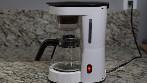 closeup of a white steel and glass coffeemaker in a home kitchen