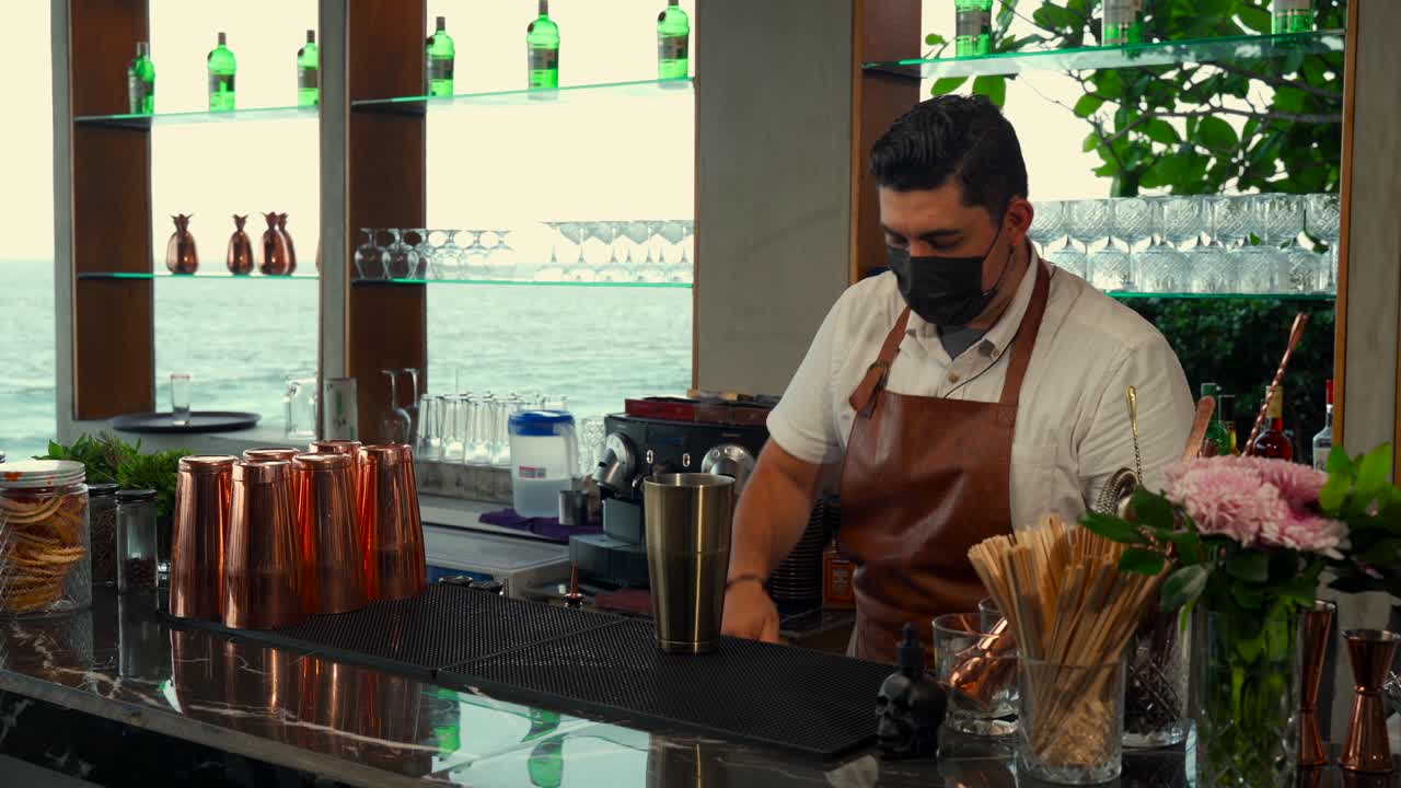 mixólogo latino mexicano preparando helado de batido en el bar de la playa restaurante espectáculo estilo rutina camarero mixología bebida bahía del caribe lado del mar
