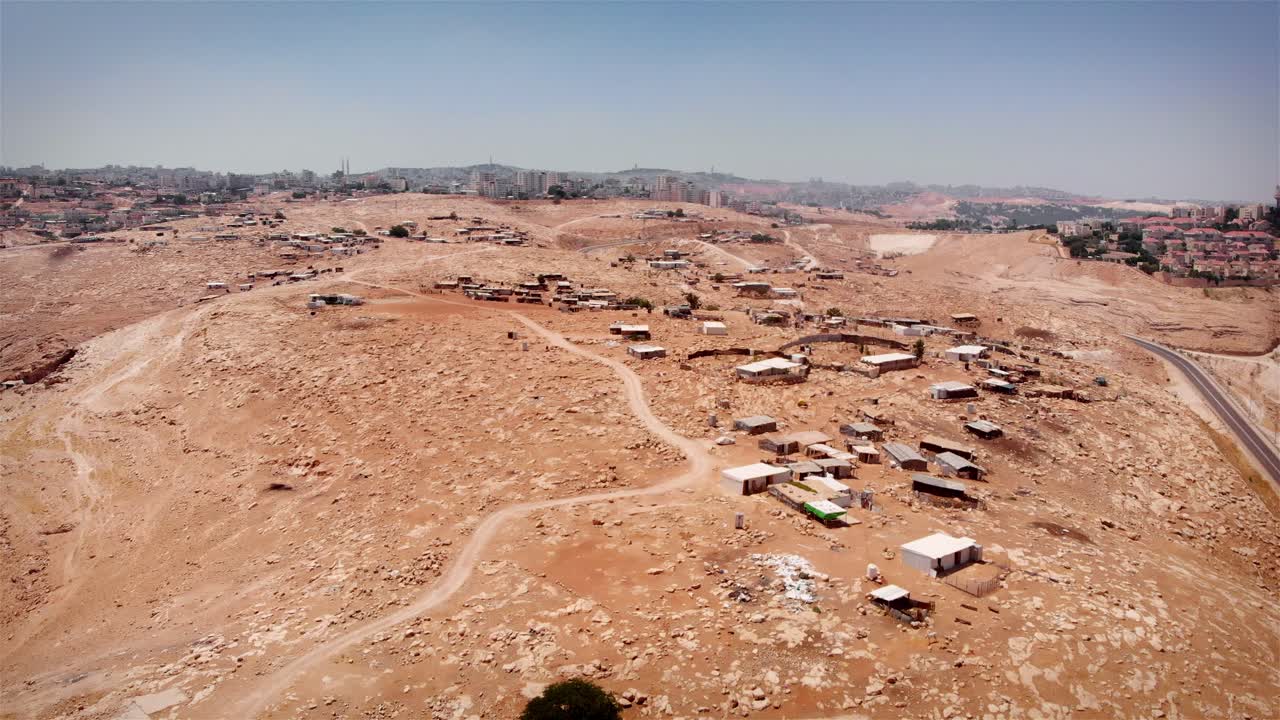 Vista aerea di un insediamento informale nel deserto adiacente a un'area urbana