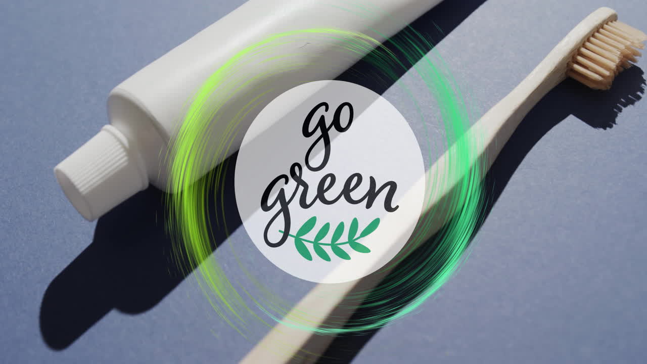 Animation of go green text and green ring over toothpaste tube and wooden toothbrush