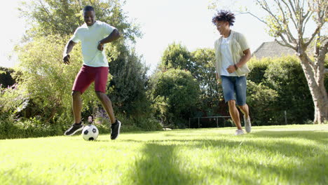 playing soccer, two multiracial male friends enjoying outdoors on sunny day in park, copy space