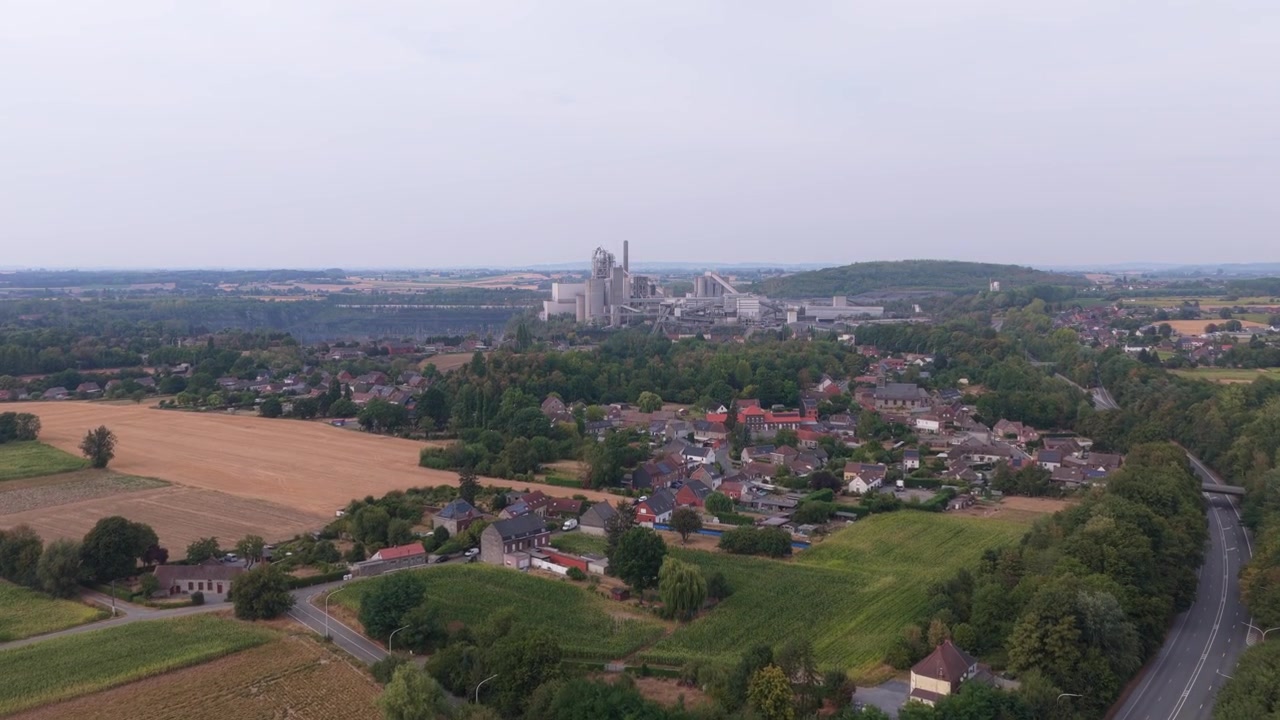 Vista aerea di un cementificio industriale vicino a un villaggio rurale