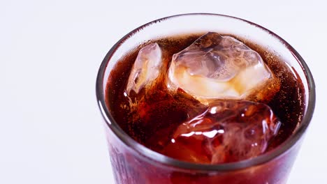 coca cola is poured into a glass from a bottle