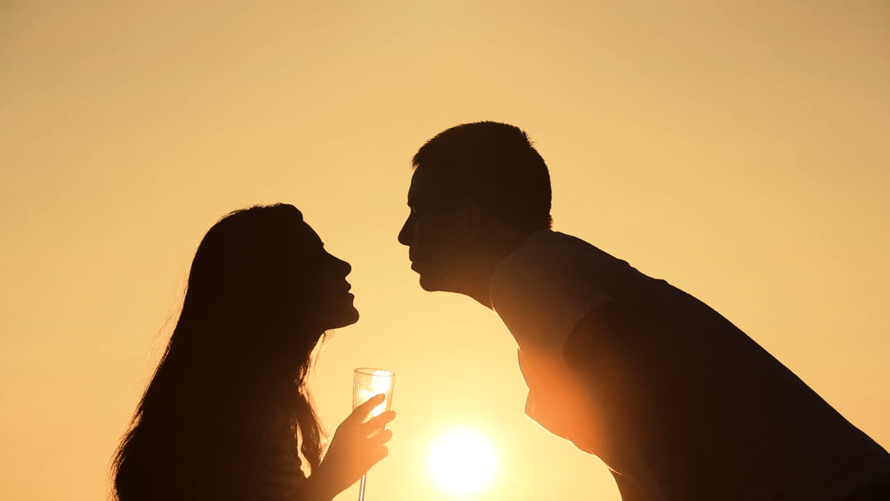 Couple kissing at sunset. Silhouette of romantic couple kissing on beach