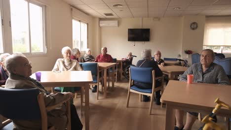 elderly men and women in nursing home canteen