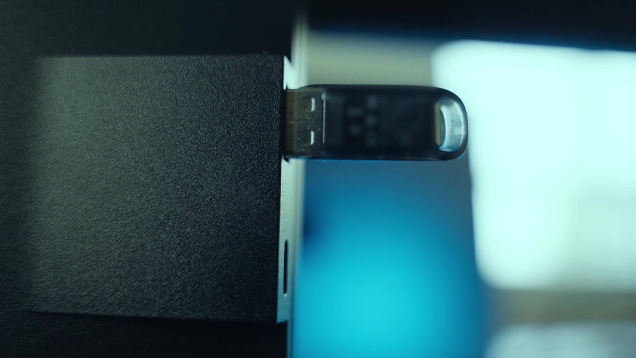 Flash drive dimasukkan ke komputer di kantor atau rumah oleh peretas atau mata-mata. Menginstal perangkat lunak atau malware ke sistem PC. Close-up tangan yang mencolokkan stik memori. Aktivitas data siber yang mencurigakan.