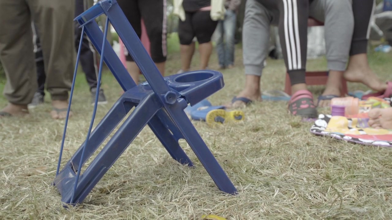 Blå børneplastikstol i venezuelansk migrantlejr i Bogota - Colombia