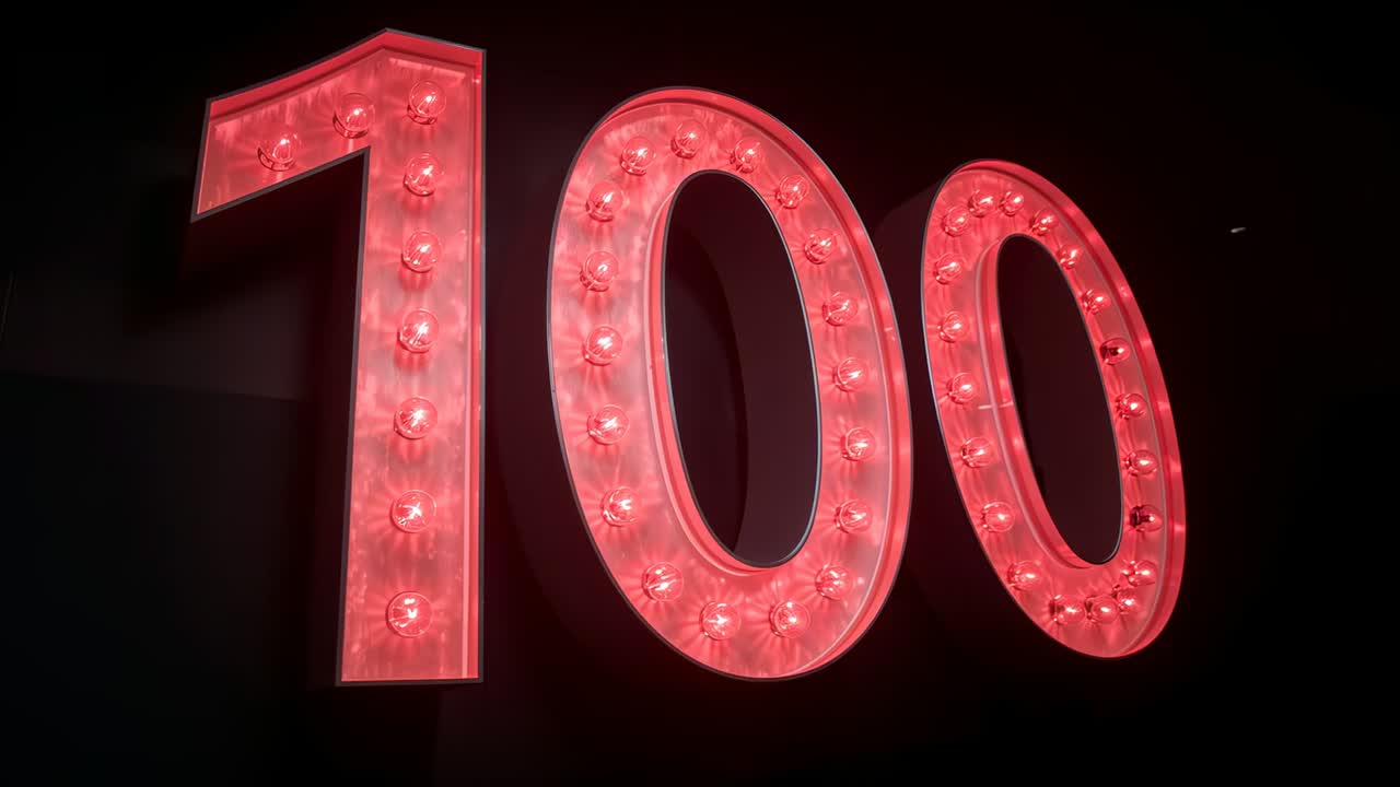 Beginning marquee sign displaying 100 and staying fully lit in dim commercial space, with red bulbs