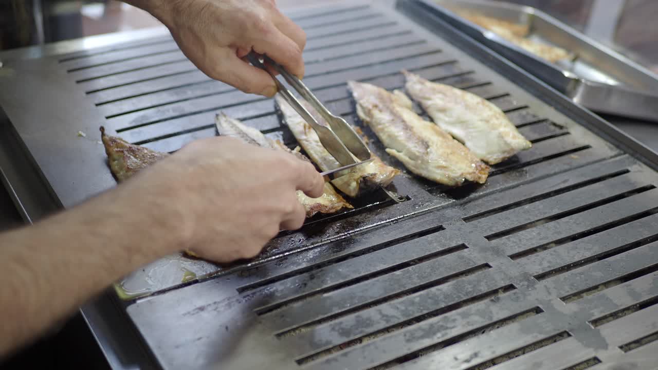 chef asando filetes de pescado fresco en una parrilla