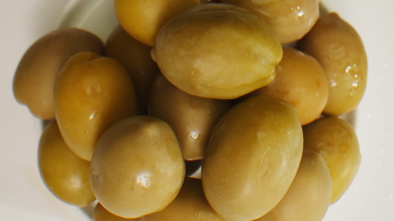 aceitunas verdes redondas en vinagre de grecia como fondo, vista de arriba. imágenes de alta calidad en 4k