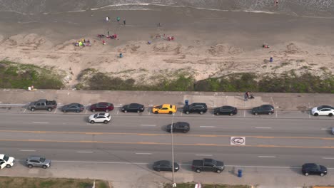 4K-Drohnenansicht-Von-Autos,-Die-Auf-Dem-Seawall-Blvd-In-Galveston,-Texas,-Fahren