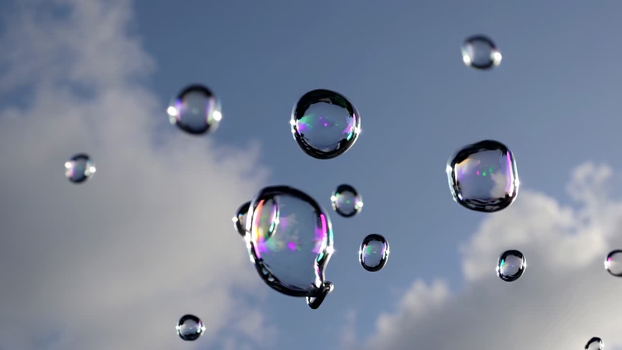 Close-up video of soap bubbles floating against a blue sky with clouds