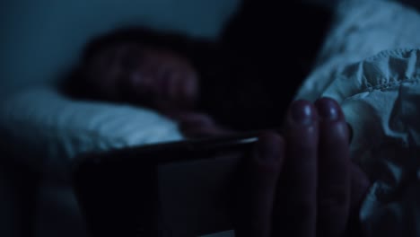 smart phone being used in bed focus pull from phone to tired woman