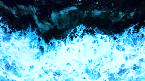 blue glowing waves crash against the cliffside