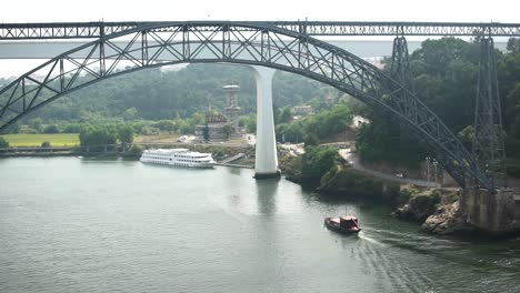 boat travelling under a large bridge