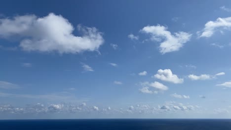 time lapse of beautiful blue sky and white clouds flowing over sea in summer season