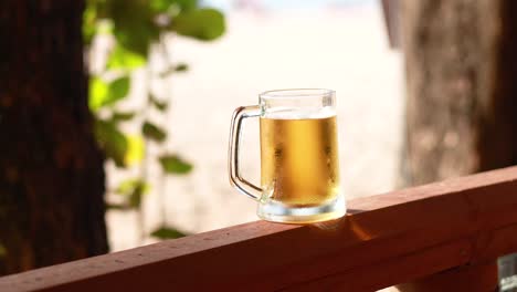 a beer mug sits on a wooden railing