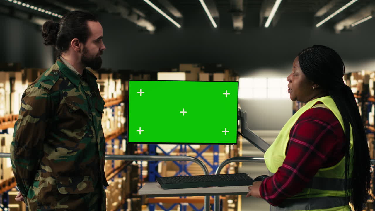Warehouse Workers Discussing Logistics with Green Screen Monitor