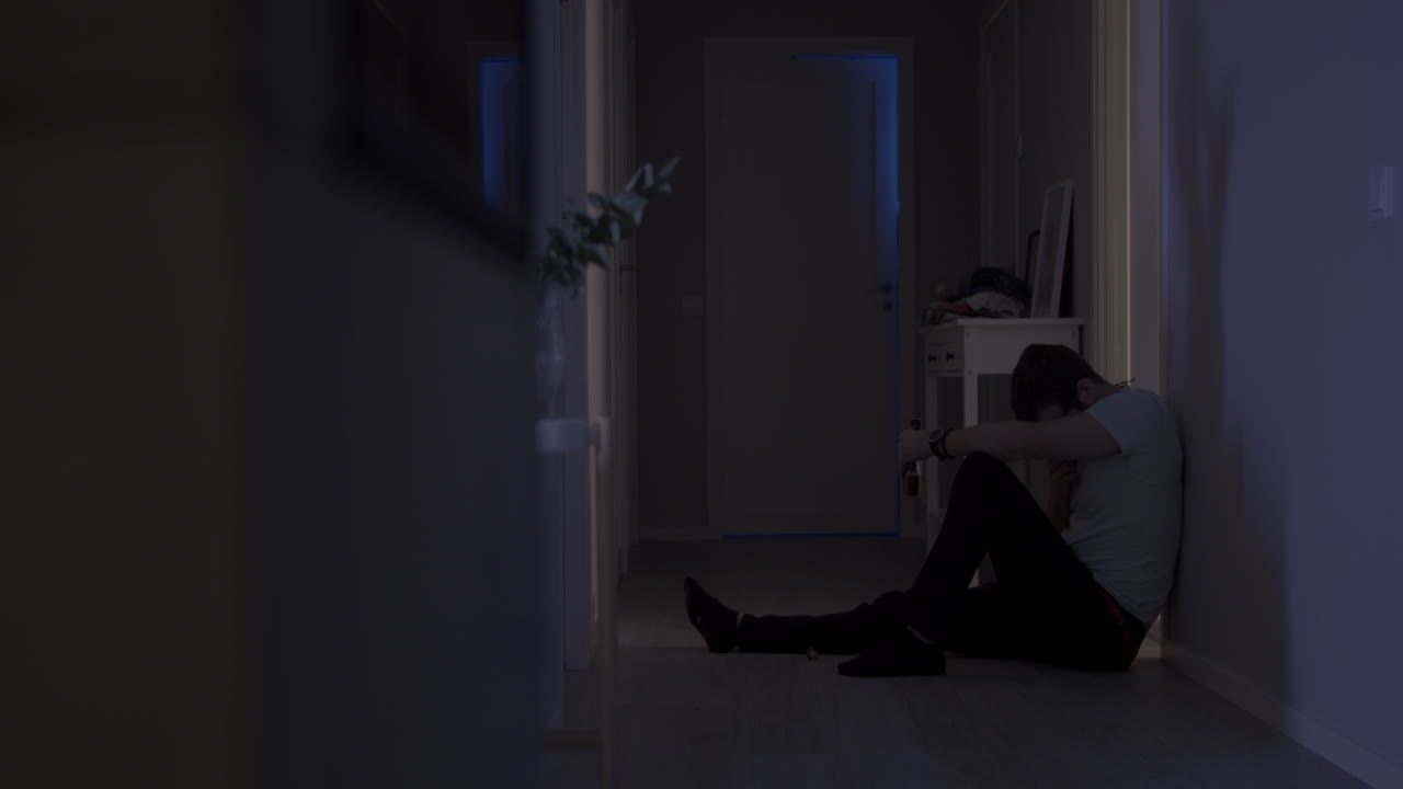 복도 바닥에 앉아 취한 젊은 남자