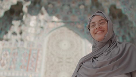 beautiful muslim woman standing near mosque