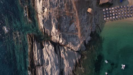 Birdseye-Aerial-View-of-Cape-and-Beach-on-Aegean-Sea,-Greece,-Reveling-Rising-Drone-Shot