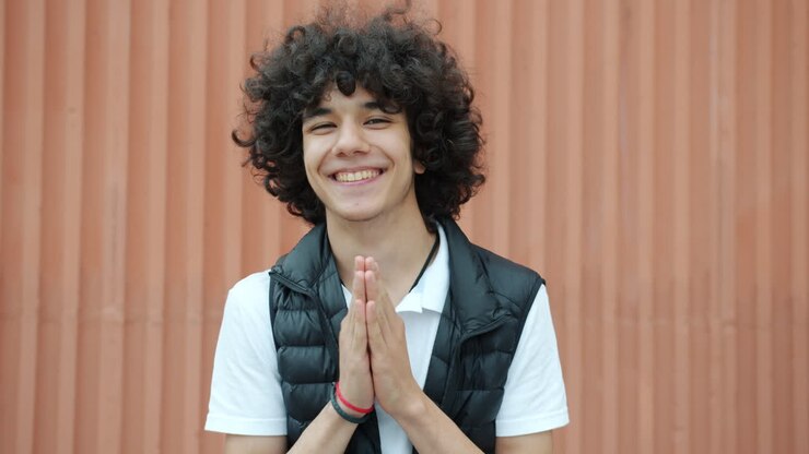 Adolescente sorridente con le mani giunte