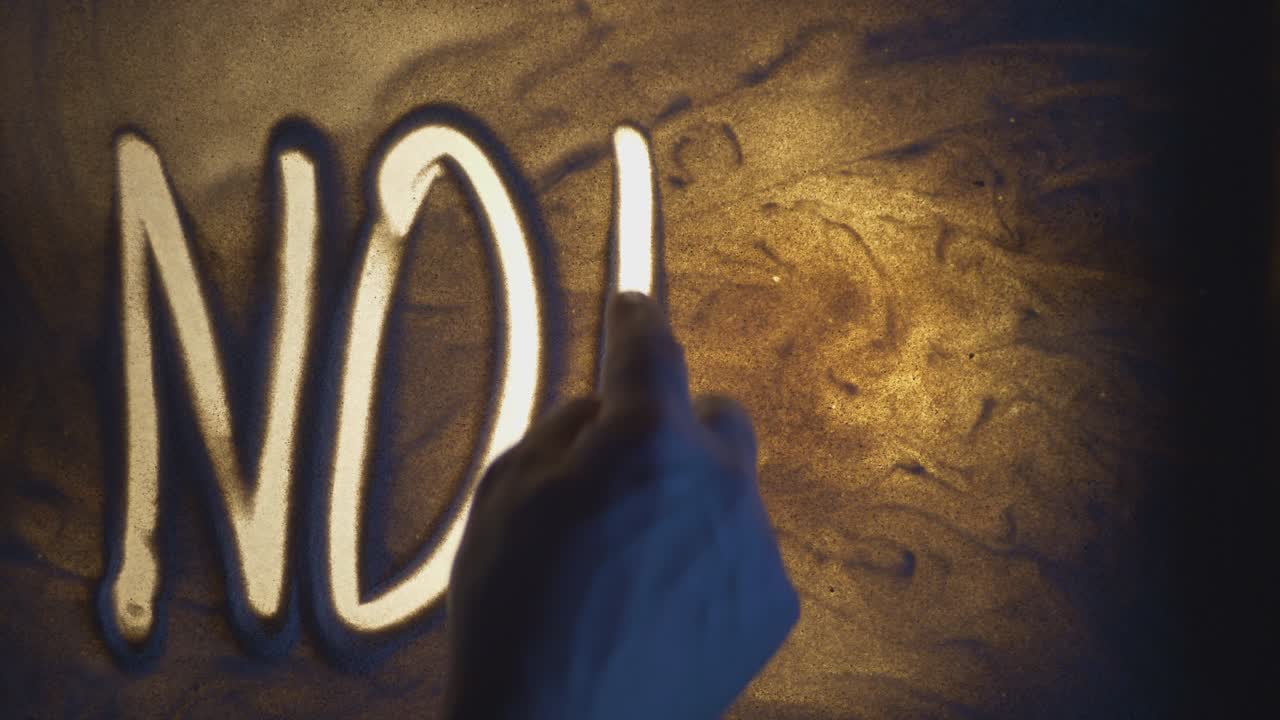 NO PANIC Inscription. Sand On Illuminated Glass