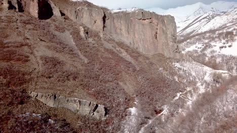 aerial view of a rugged mountain area with cliffs ahead and a hiking path below