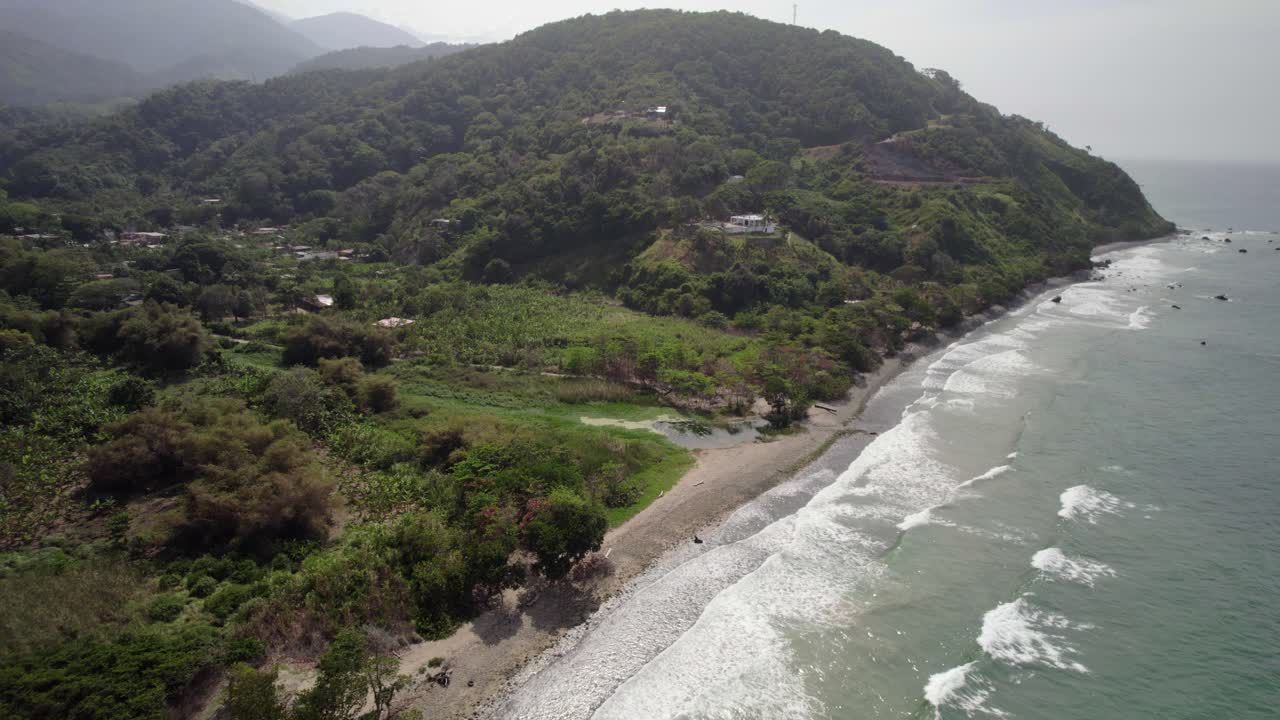 Aerial shot of coastline and river mouth near La Guaira, lush green hills