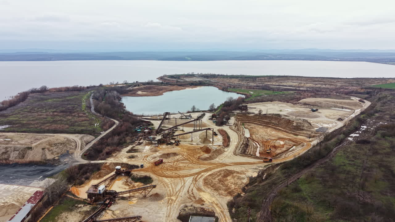 Construction site near lake with machinery and land development in progress in autumn at a rural location