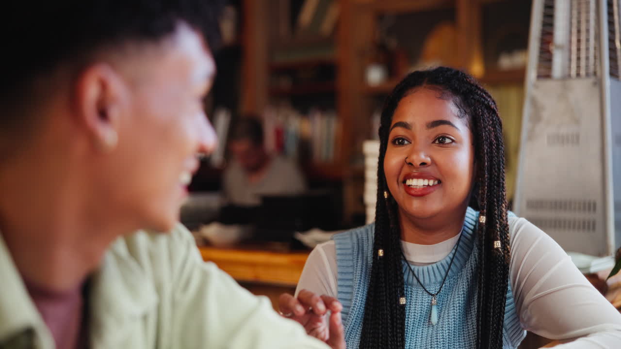 Two young adults enjoying a conversation at a restaurant