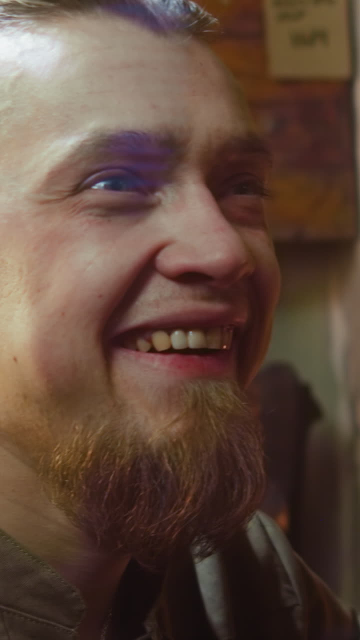 un alcohólico feliz cae en la silla bajo una mano pesada en la taberna. un hombre borracho con una sonrisa estúpida ve a un extraño interesante y trata de levantarse en una casa de huéspedes medieval