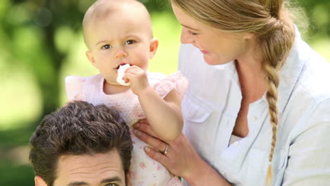 padres felices con su niña en el parque