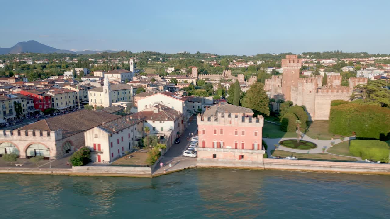 관광객들이 호숫가 산책로에 줄을 서면서 고대 건물들이 저녁 노을에 흠뻑 젖어 있다