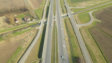 aerial flyover driving highway surrounded by agricultural fields during sunlight