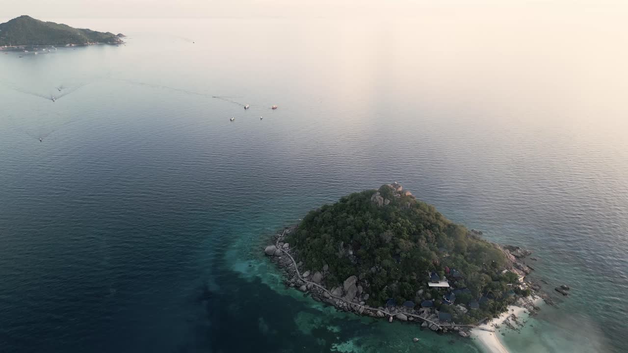 태국 만의  유안 (nang yuan) 과 코 타오 섬 (koh tao island) 을 드러낸 드론은 해가 지면 바다를 항해하는 배와 함께 위에서 아래로 날아갑니다.
