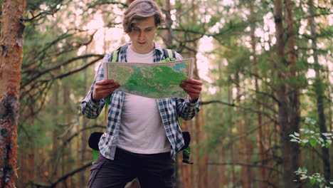 man hiking and reading map in a forest