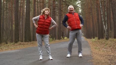 senior couple chatting and stretching together in the forest