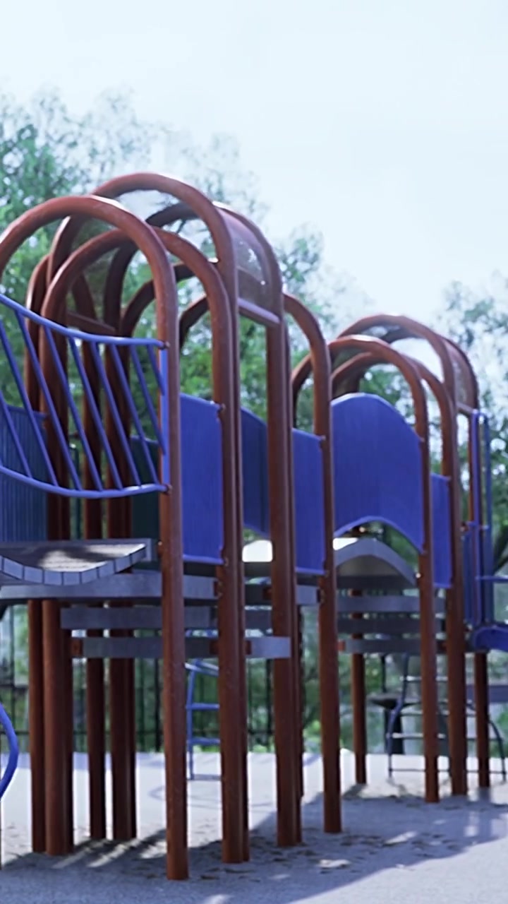 Kinder spielen in einem Park mit einer Holzbank und einem Klettergerüst aus Metall