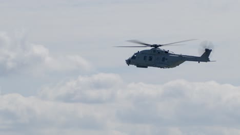 helicóptero de transporte militar volando en una pista de vista de perfil en un día soleado