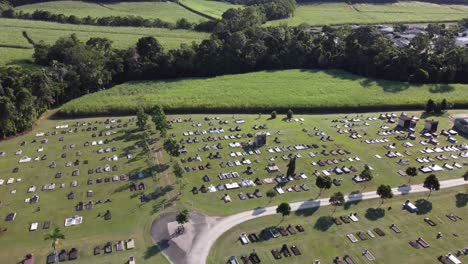 4k aerial view of a cemetery drone flying over gravestones toward the neighbouring sugarcane plantation in north queensland, australia