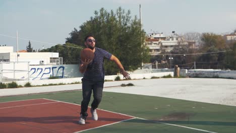 el jugador de baloncesto masculino corre y salta para disparar a un clip corto en cámara lenta de aro