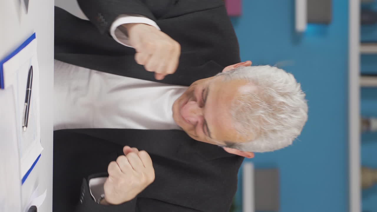 홈 오피스 직원의 수직 비디오 남자가 카메라를 바라보며 춤을 춘다.