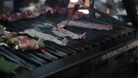 Slow-motion-shot-of-a-chef-turning-over-his-meat-on-a-bbq-to-cook-fully