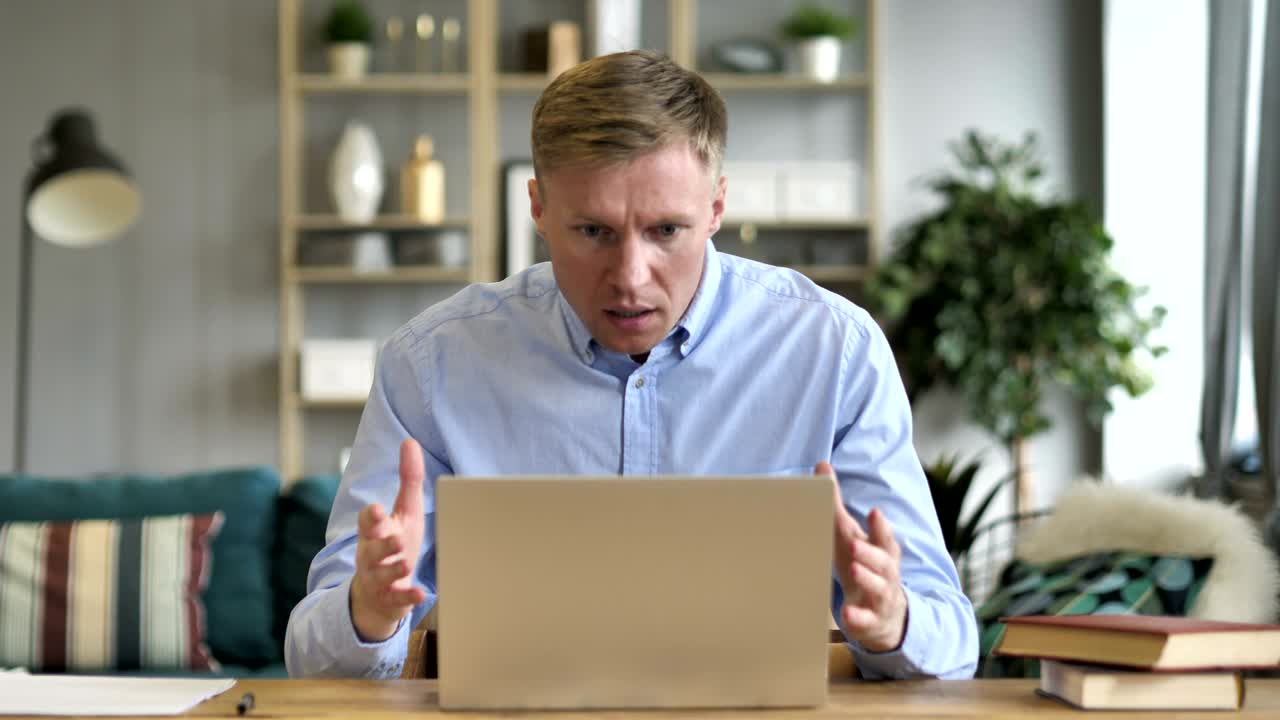 un hombre de negocios en estado de shock mientras trabaja en una computadora portátil.